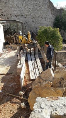 transport des pierres plates pour renforcer la construction du vieux mur en pierres au chateau féodal d' ollioules